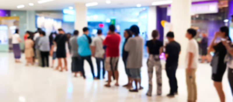 Group of people standing in a queue or line, waiting to purchase a popular item