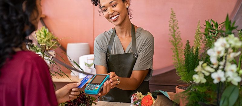 Woman holding a card reader device to process a payment transaction.