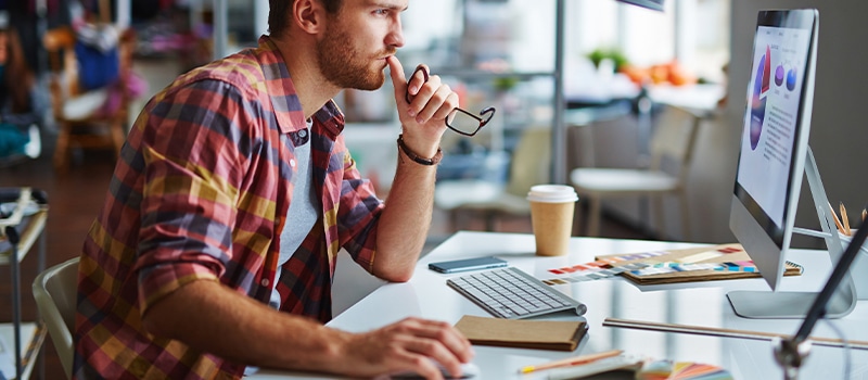 Modern designer sitting in front of computer in office