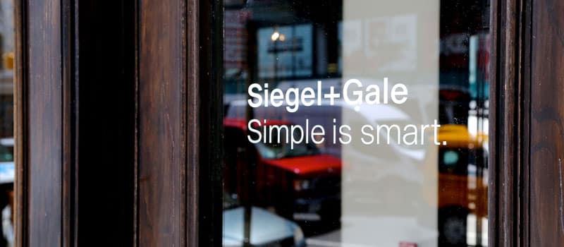 siegel + gale logo in window glass door